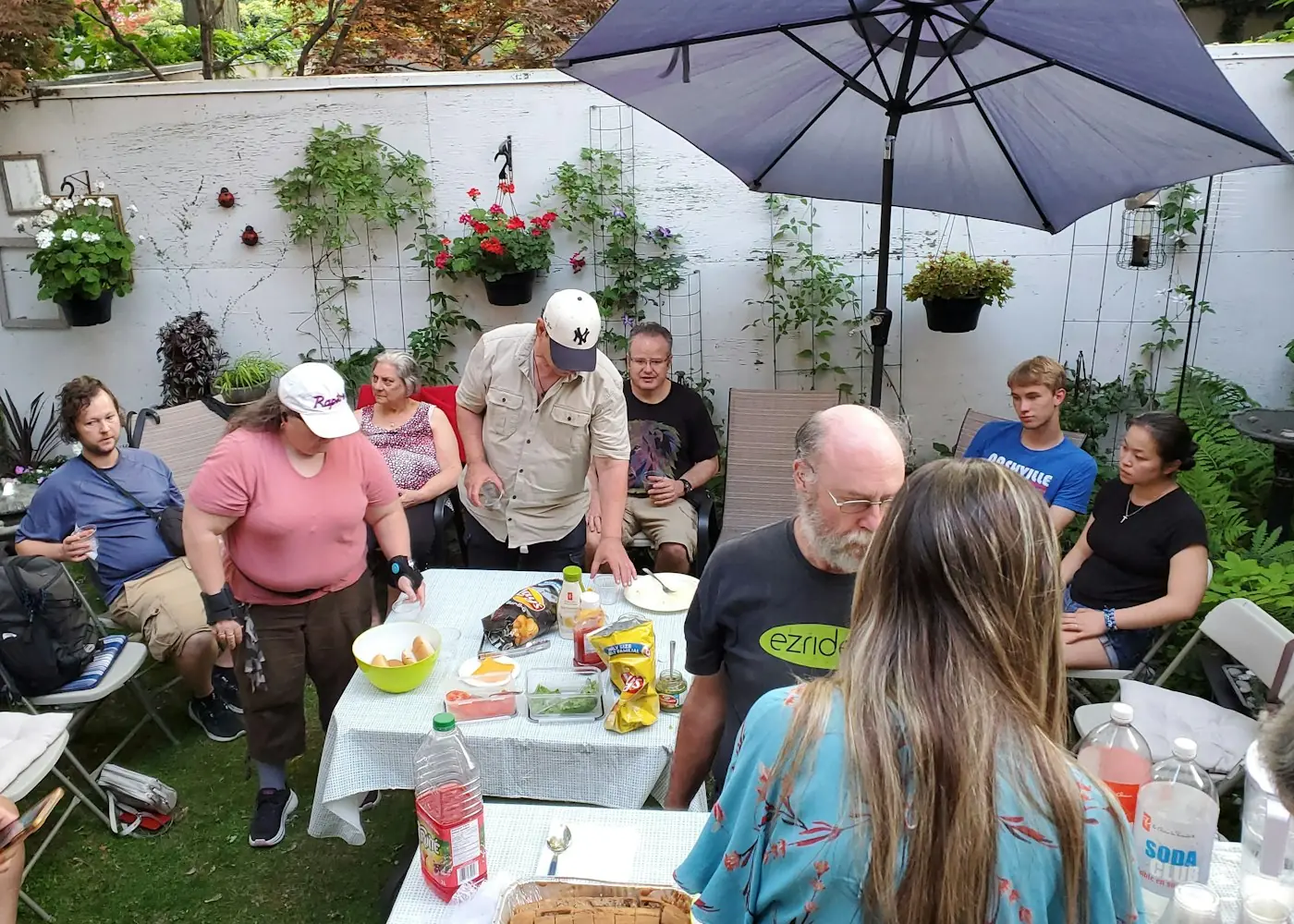 Menschen verschiedenen Alters sitzen gemeinsam im Garten